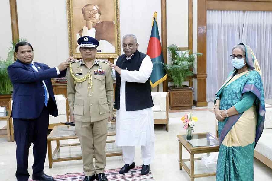 Home Minister Asaduzzaman Khan and Senior Secretary of the Public Security Division under the Ministry of Home Md. Akhtar Hossain adorning the rank badge to new IGP Chowdhury Abdullah Al Mamun in presence of Prime Minister Sheikh Hasina at Ganabhaban on Wednesday –PID Photo