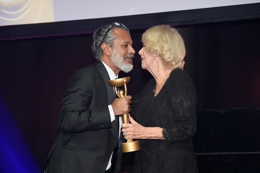 Britain's Queen Camilla presents winner Shehan Karunatilaka with trophee for "The Seven Moons of Maali Almeida" at the Booker Prize for Fiction 2022 awards ceremony, in London, Oct 17, 2022. REUTERS/Toby Melville