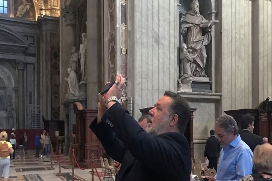 Actor Russell Crowe uses his smartphone inside St. Peter's Basilica after attending a special screening in the Vatican of the new film "The Greatest Beer Run Ever" for recruits of the Vatican's gendarmes and Swiss Guard, and for Marines guards from the US embassy in Rome, at the Vatican, October 17, 2022. REUTERS/Phil Pullella