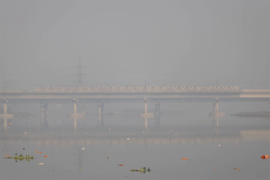 A metro train moves over a bridge built over the Yamuna river on a smoggy morning in the old quarters of Delhi, India on November 2, 2022  — Reuters photo