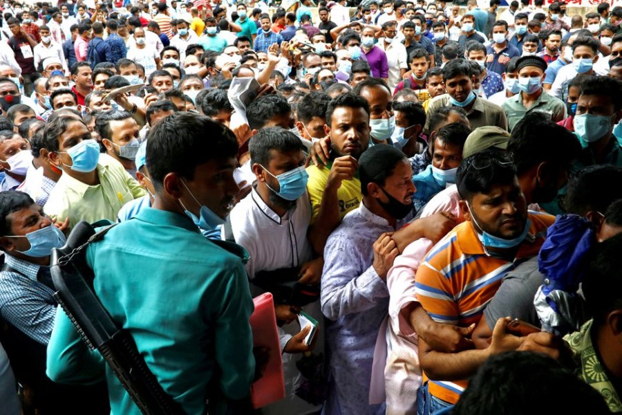 Police try to control the crowd as stranded Bangladeshi workers gatheroutside of the Biman Bangladesh Airlines office, demanding flight tickets to go back to Saudi Arabia, in Dhaka, Bangladesh on September 24, 2020 — Reuters/Files