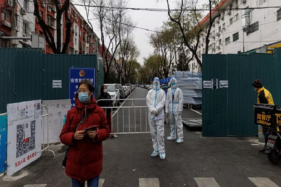 Epidemic-prevention workers in protective suits stand guard at a residential compound as outbreaks of coronavirus disease continue in Beijing, China Nov 28, 2022. REUTERS