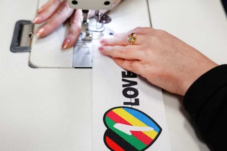 A woman sews Velcro on to a One Love armband, which is banned by FIFA at the World Cup Qatar 2022, in Utrecht, Netherlands November 23, 2022.REUTERS/Staff