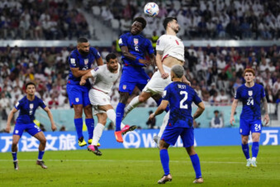 Players fight for a header during the World Cup group B soccer match between Iran and the United States at the Al Thumama Stadium in Doha, Qatar, Tuesday, Nov. 29, 2022. (AP Photo/Manu Fernandez)