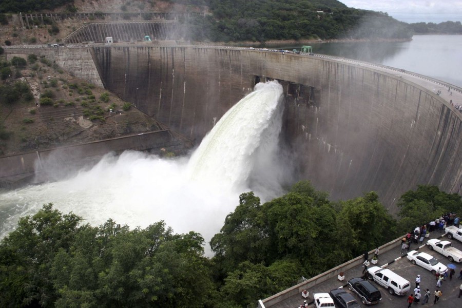 People watch as the spillway gates are opened at Kariba North Bank dam on Lake Kariba to reduce rising water levels as a measure to protect the dam February 11, 2008. Zambia and neighbour Zimbabwe said on Monday they had placed military forces on flood alert after opening a floodgate at a key dam that is expected to force Mozambique to evacuate 100,000 people REUTERS/Mackson Wasamunu (ZAMBIA)