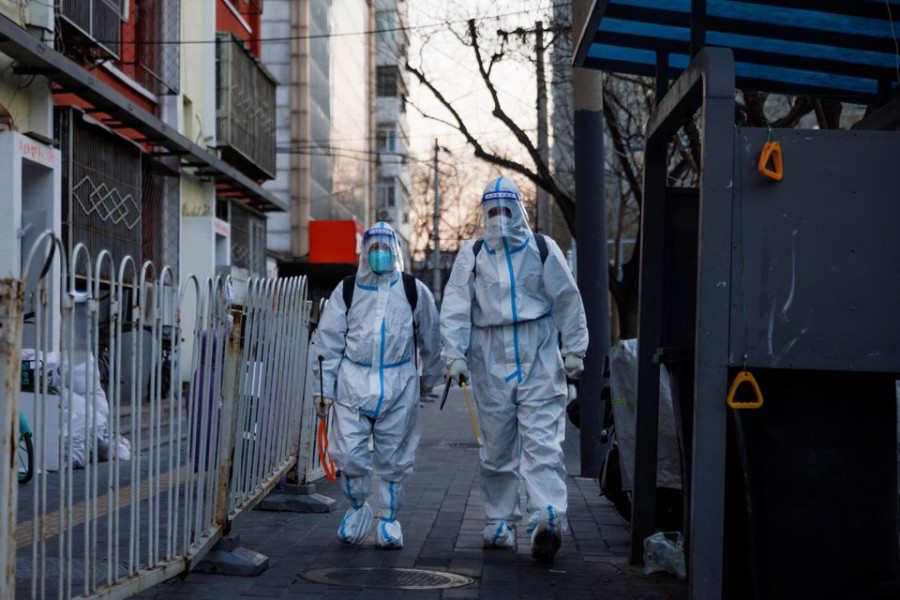 Pandemic prevention workers in protective suits walk in a street as coronavirus disease (COVID-19) outbreaks continue in Beijing, December 4, 2022. REUTERS/Thomas Peter