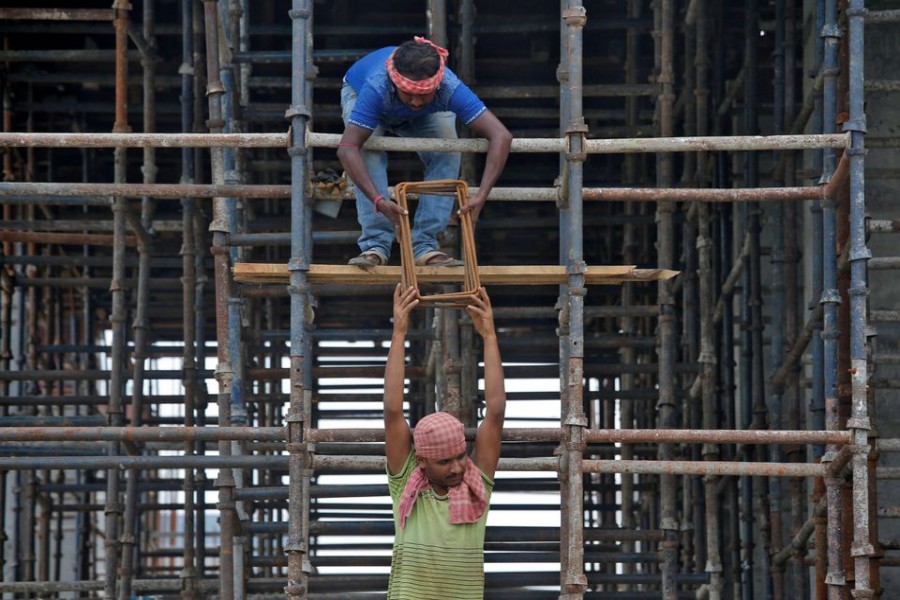 Labourers work at the construction site of a residential building on the outskirts of Kolkata, India, July 5, 2019. REUTERS/Rupak De Chowdhuri/Files