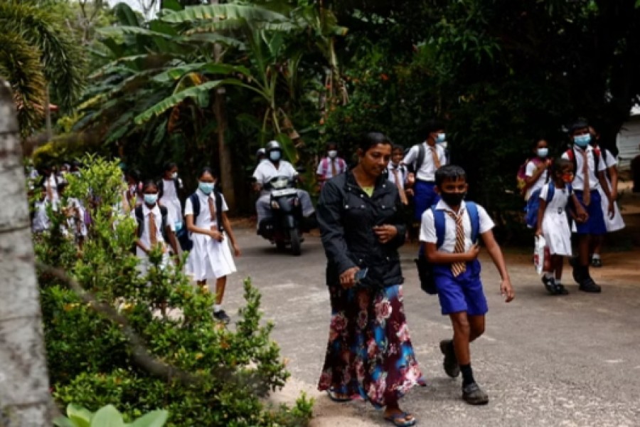 Meenu Mekala, 44, and her youngest son Minula Nimsara, 11, walk back home after school, in Kudamaduwella, Sri Lanka, July 28, 2022. The high price of one Sri Lankan family's desperate bid to flee crisis. REUTERS