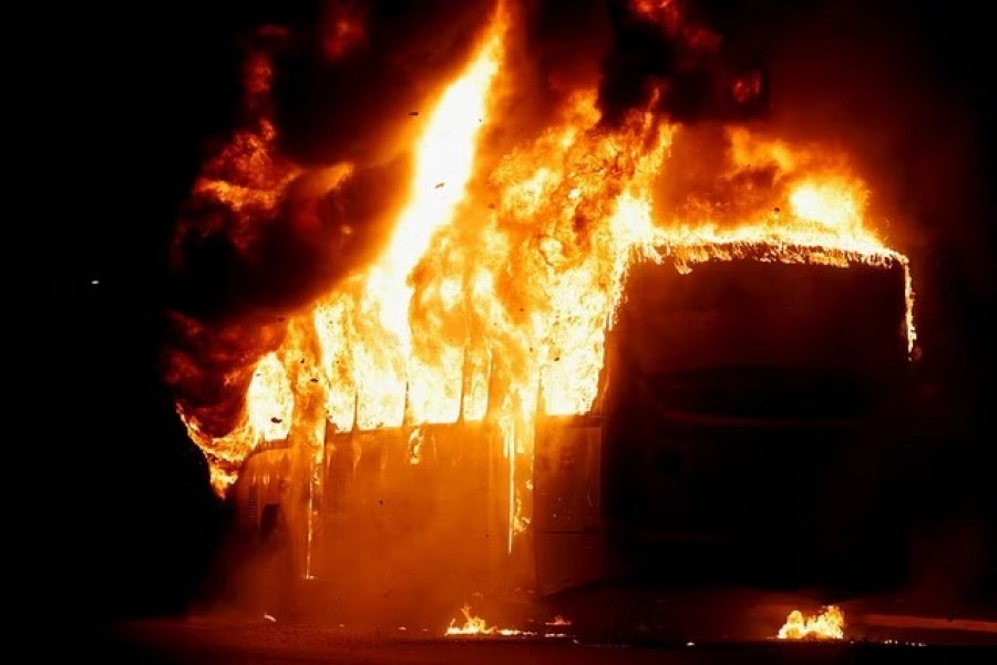 A bus is seen on fire as supporters of Brazil's President Jair Bolsonaro protest after supreme court justice Alexandre de Moraes ordered a temporary arrest warrant of indigenous leader Jose Acacio Serere Xavante for alleged anti-democratic acts, in Brasilia, Brazil, December 12, 2022. REUTERS