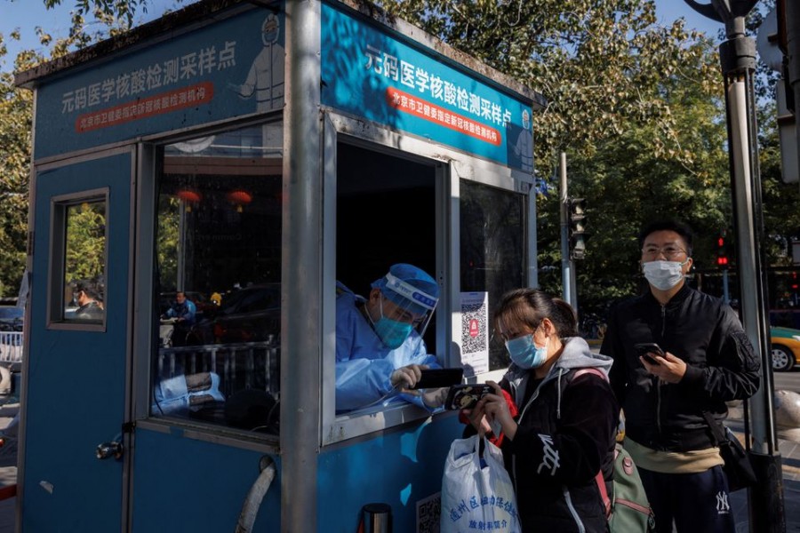 A pandemic prevention worker records personal details of people as they line up to get swab tests at a testing booth as outbreaks of coronavirus disease (Covid-19) continue in Beijing, China on November 3, 2022 — Reuters/Files