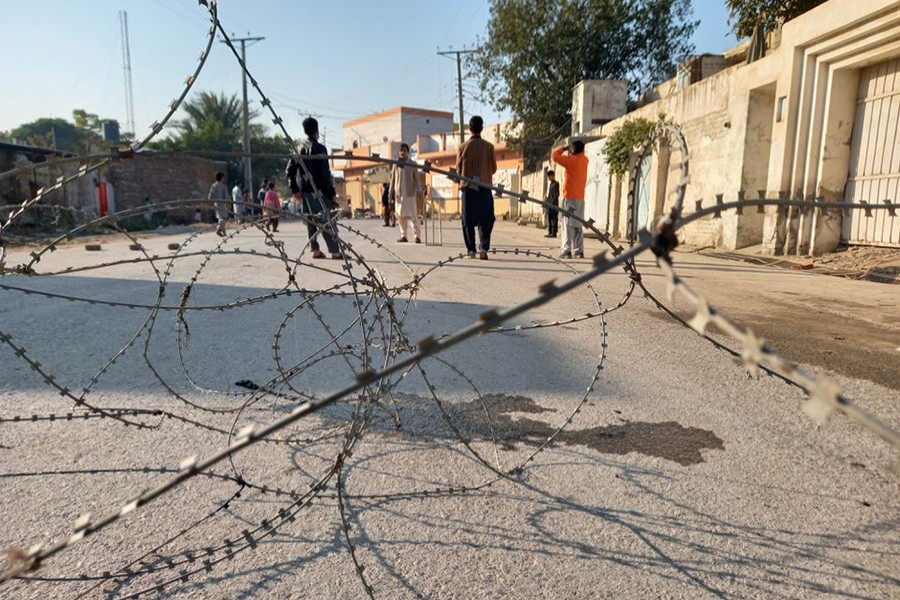 Residents play cricket on a street sealed with barbed wire in Bannu, Pakistan on December 20, 2022 — Reuters photo