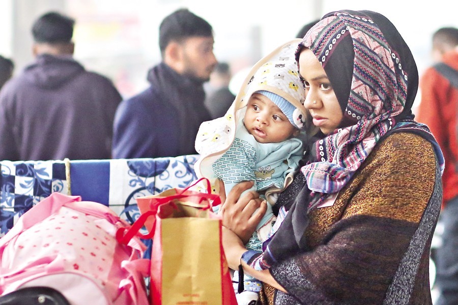 With a mild cold wave sweeping across Dhaka and elsewhere, this mother and her baby, carefully wrapped in warm clothes, are waiting before embarking on a journey at Kamalapur railway station in the capital. The photo was taken around 4:00pm on Wednesday — FE photo by KAZ Sumon