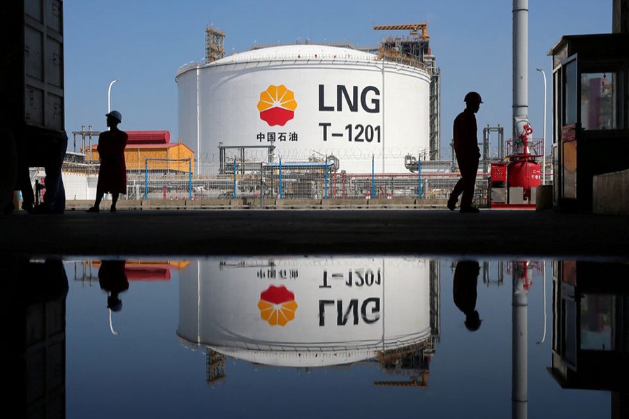 A liquified natural gas(LNG) storage tank and workers are reflected in a puddle at PetroChina's receiving terminal at Rudong port in Nantong, Jiangsu province, China September 4, 2018. Picture taken on September 4, 2018 — Reuters/Files