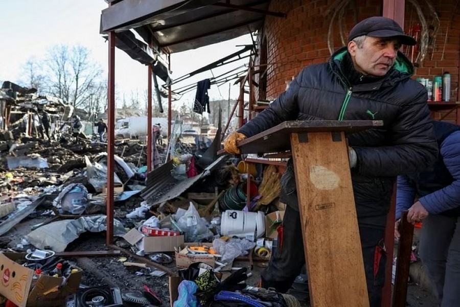 Local residents look through items at a site of the local market, heavily damaged by a Russian missile strike, amid Russia's attack on Ukraine, in the Shevchenkove town, Kharkiv region, Ukraine January 9, 2023. REUTERS