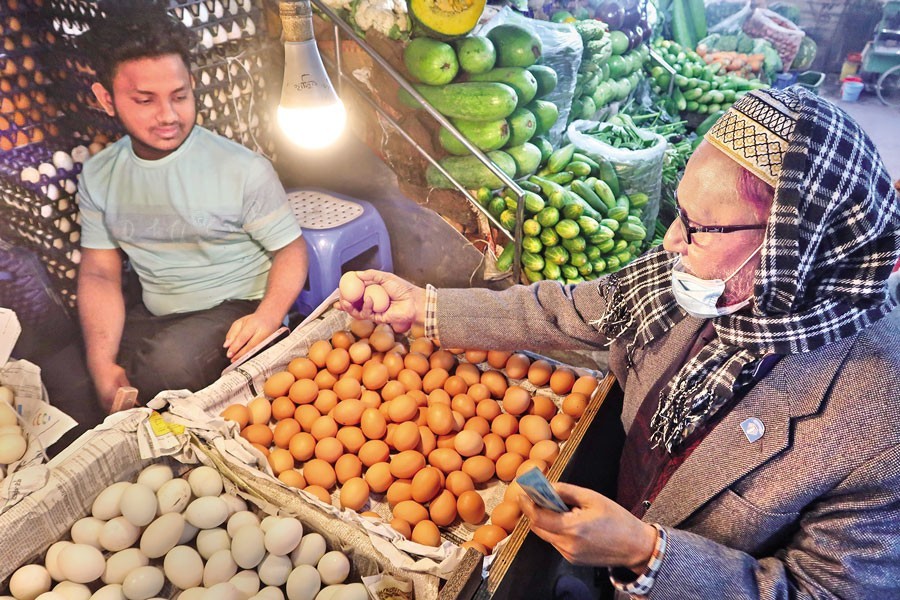 A customer is buying eggs from a shop at a kitchen market in Dhaka's Segunbagicha area on Thursday. Egg prices have further increased in a span of one week. — FE photo