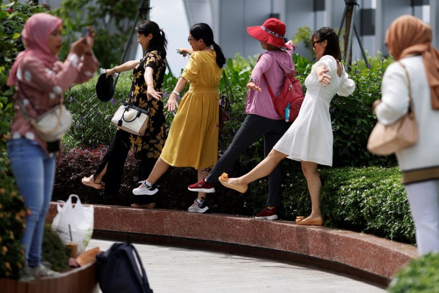 Tourists and visitors pose for photos at a rooftop observatory in Singapore July 26, 2022. REUTERS/Edgar Su