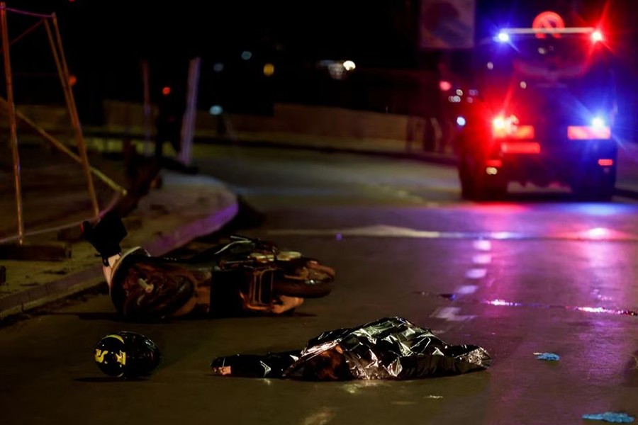 Israeli forces work next to a covered body at the scene of a shooting attack in Neve Yaacov which lies on occupied land that Israel annexed to Jerusalem after the 1967 Middle East war on January 27, 2023 — Reuters photo