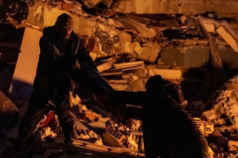 People gather boxes on the remains of a destroyed building in the aftermath of a deadly earthquake in Elbistan, Turkey on February 14, 2023 — Reuters photo