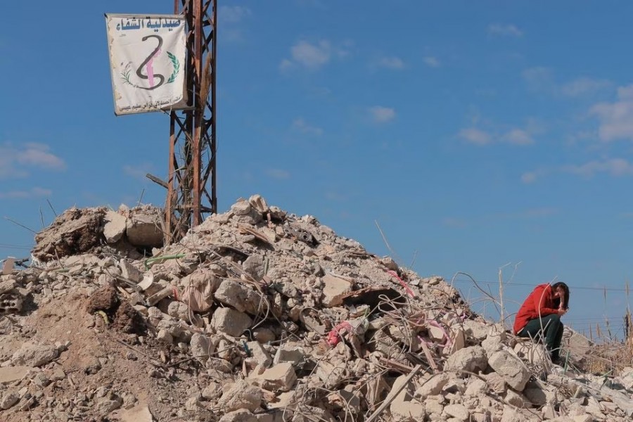 A woman sits on the rubble of her destroyed home that was hit by a deadly earthquake in Jableh, Syria on February 17, 2023 — Reuters photo