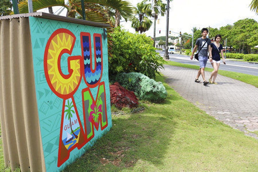 A file photo shows tourists walking through a shopping district in Tamuning, Guam. - AP