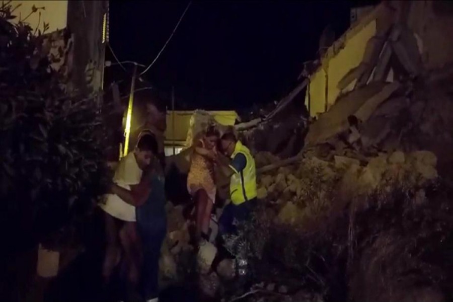 A woman is helped out of debris and rubble after an earthquake hit the island of Ischia, off the coast of Naples, Italy on Monday.