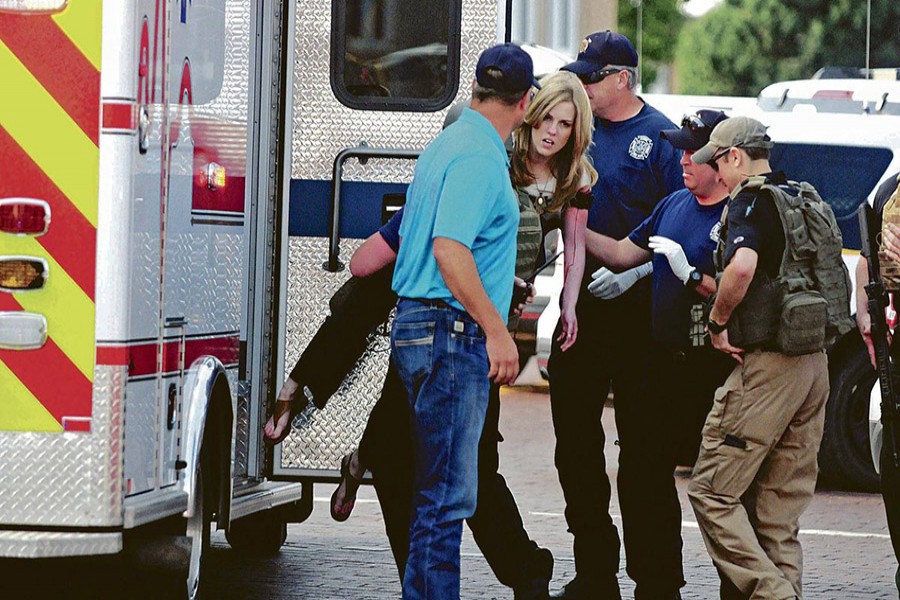 An injured woman is carried to an ambulance in Clovis, New Mexico on Monday, as authorities respond to reports of a shooting inside a public library. - AP photo