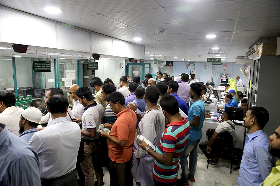 People standing in queues inside a bank
