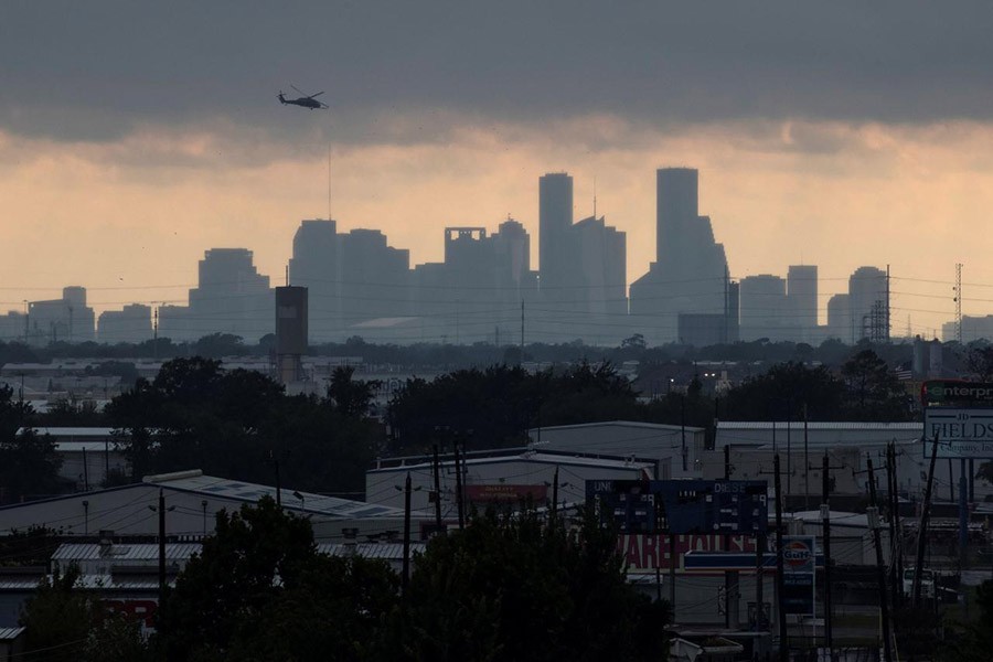 A helicopter hovers above the Houston skyline as sunlight breaks through storm clouds from Tropical Storm Harvey in Texas, US on Tuesday. - Reuters photo