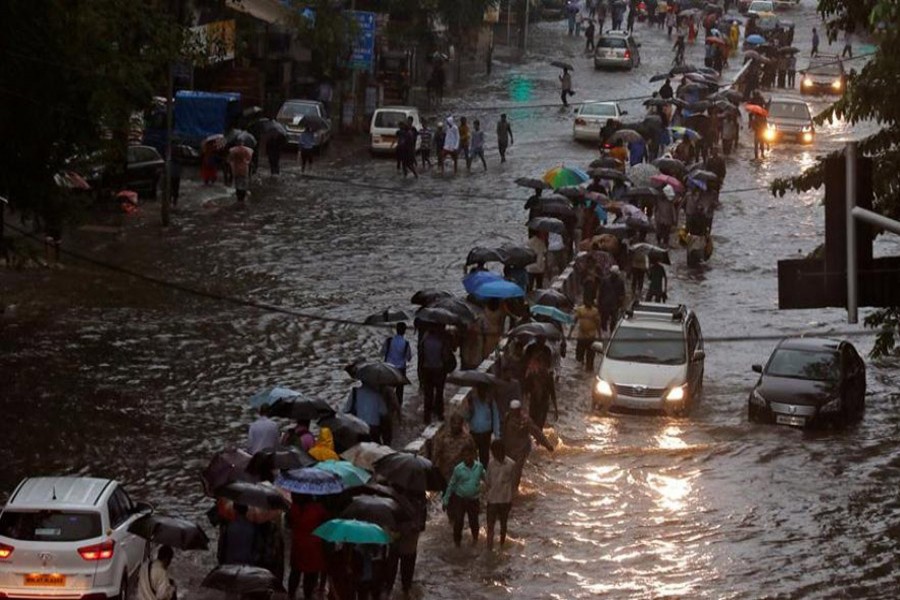 Commuters walk through water-logged roads after rains in Mumbai, India on Tuesday.