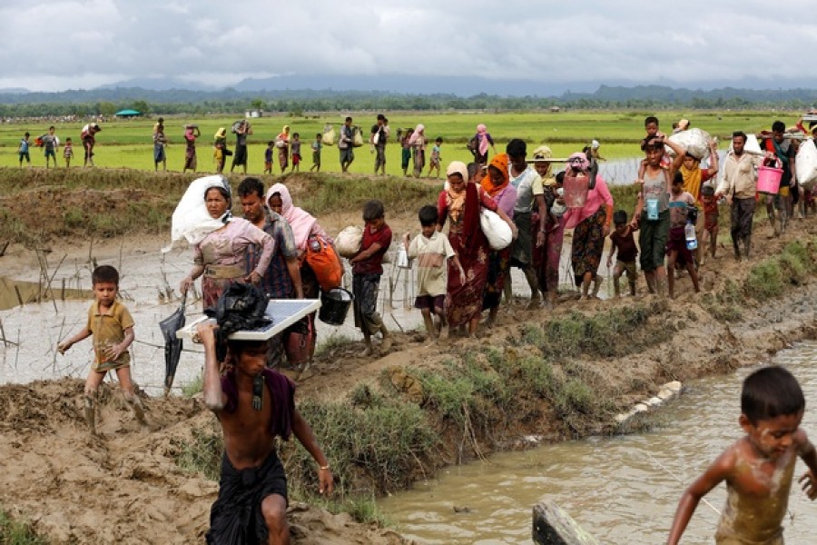 Rohingya refugees walk toward Bangladesh after crossing the Bangladesh-Myanmar border in Teknaf on Sept 1.--Reuters