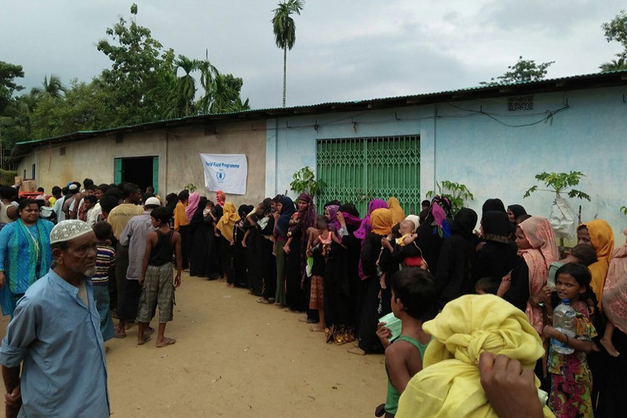 People newly arrived in Cox’s Bazar from Myanmar queue up to receive an emergency ration of high-energy biscuits. Photo: WFP
