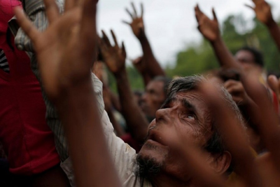 Rohingya refugees stretch their hands to receive food distributed by local organizations in Kutupalong, Bangladesh, September 9, 2017. Reuters