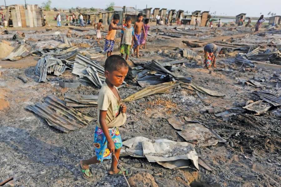 A boy walks among debris after fire destroyed shelters at a camp for internally displaced Rohingya Muslims in the western Rakhine State near Sittwe.  	—Photo: Reuters