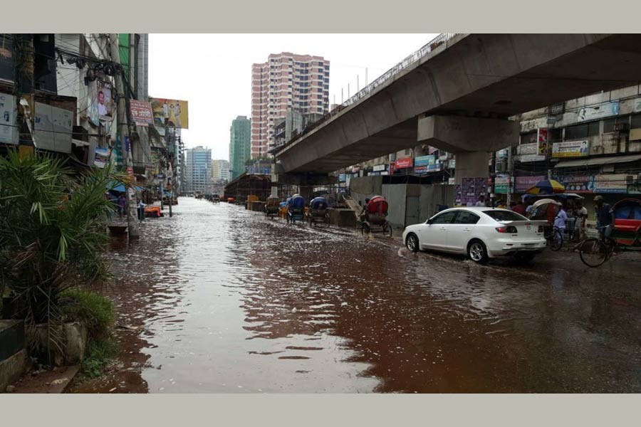 A car is plying along a waterlogged road under an under-construction flyover in Dhaka city. File Photo