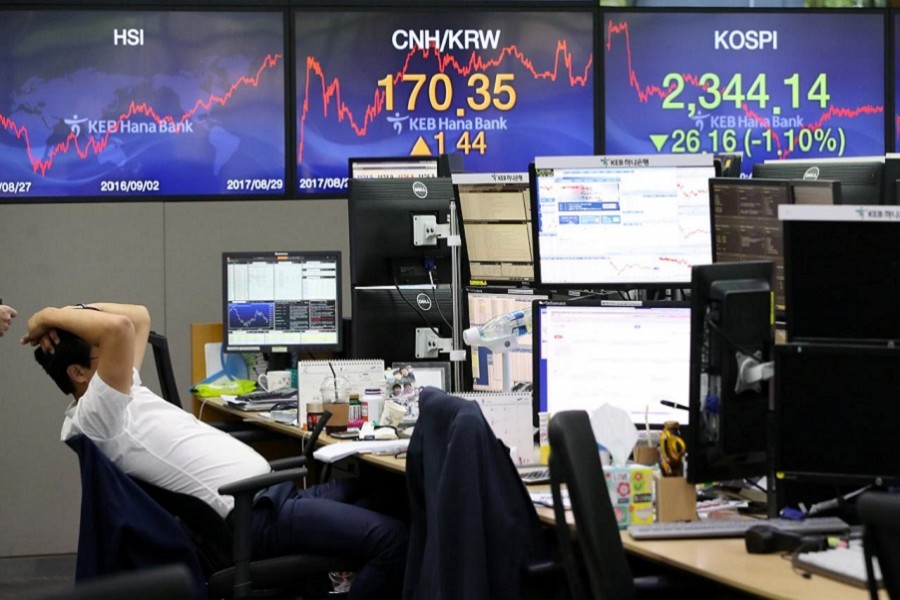 A currency dealer works in front of electronic boards showing the Korea Composite Stock Price Index (KOSPI) (R) at a dealing room of a bank in Seoul, South Korea August 29, 2017. Reuters