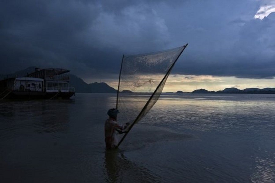A man catches fish in the Brahmaputra river in Guwahati, India August 28, 2017. Reuters/FIles