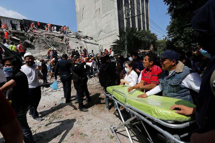 Paramedics wait as rescue personnel search for people in the rubble of a collapsed building after an earthquake hit Mexico City, Mexico on Tuesday. - Reuters photo