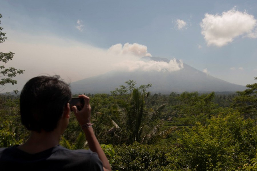 A local resident takes a picture of Mount Agung, an active volcano on Bali, Indonesia. - Reuters photo