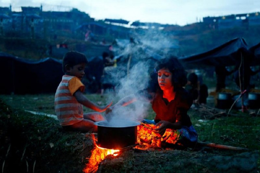 Rohingya refugee girl cooks a meal in an open place near Balukhali in Cox’s Bazar, Bangladesh, Sept 4, 2017. Reuters