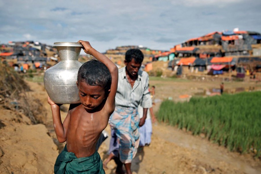 A Rohingya refugee boy carries water in Cox's Bazar, Bangladesh, Sept 27, 2017. - REUTERS