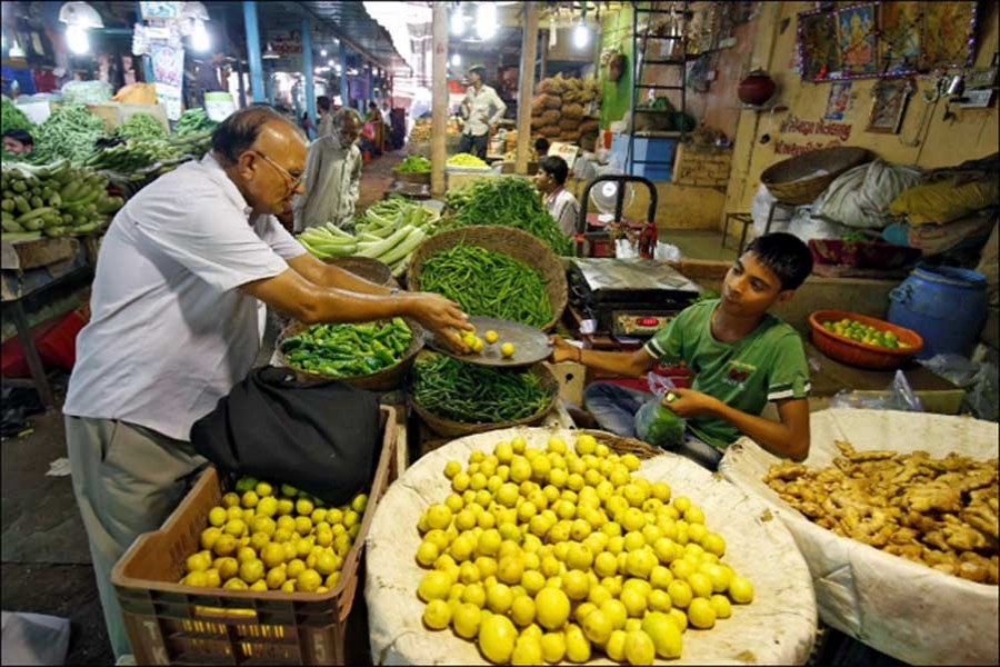 A man buys lemons at a market in Ahmedabad.  - Reuters photo
