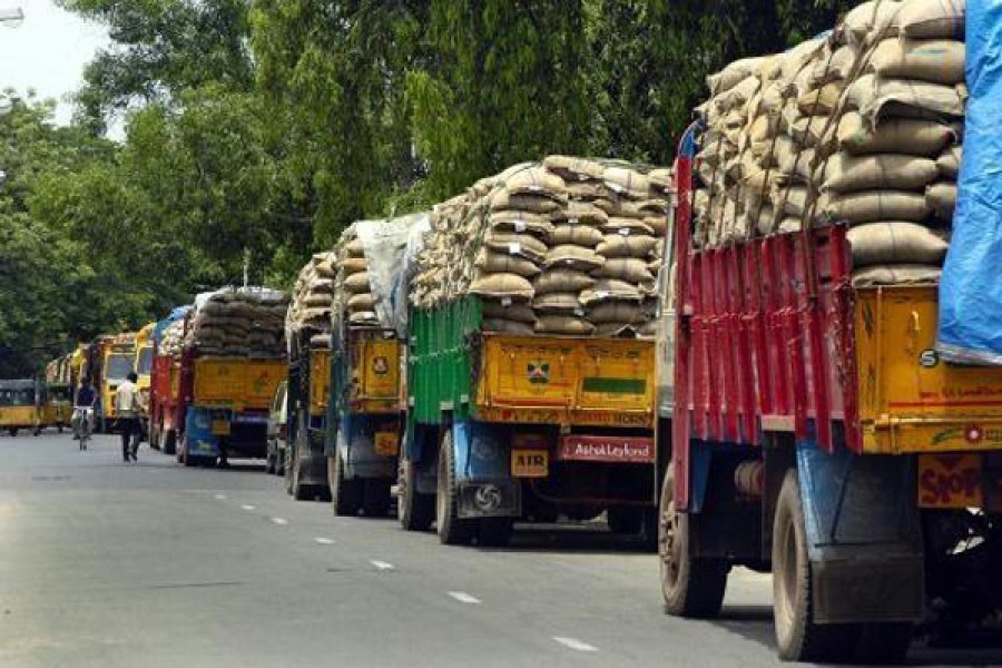 File photo shows trucks standing laden with rice, the prices of which have recently soared causing the government to import it from a few countries, including Myanmar and Cambodia.