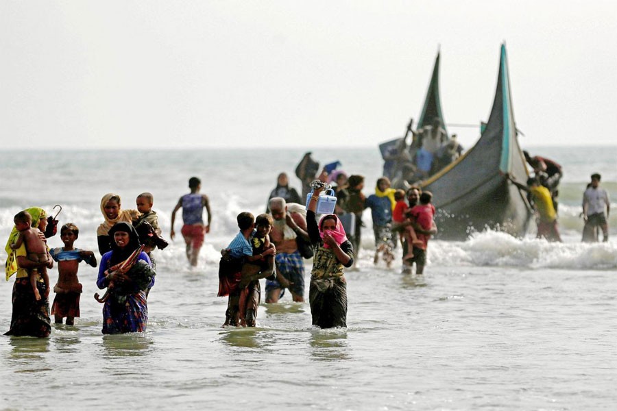 Rohingya refugees walk to the shore after crossing the Bangladesh-Myanmar border by boat through the Bay of Bengal in Teknaf, Bangladesh (REUTERS file photo)