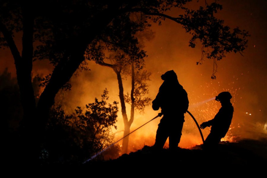 Firefighters work to extinguish flames from a forest fire in Cabanoes near Lousa, Portugal on Monday. - Reuters photo