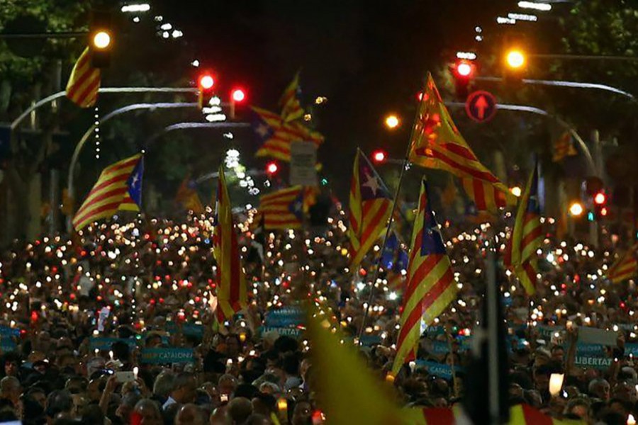 Protesters hold banners, candles and wave flags during a protest in Barcelona, Spain on Wednesday. - Reuters photo