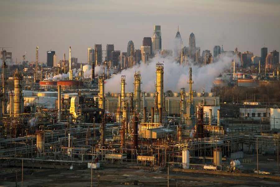 The Philadelphia Energy Solutions oil refinery owned by The Carlyle Group is seen at sunset in front of the Philadelphia skyline. 	— Reuters