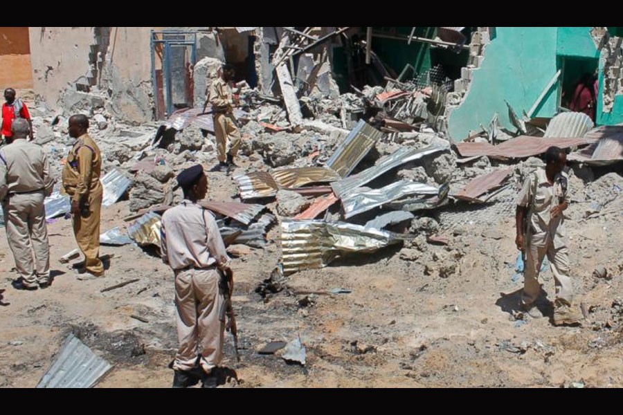 Somali soldiers look at the destroyed houses amidst the wreckage of a car bomb blast in Mogadishu, Somalia. (Photo: AP)