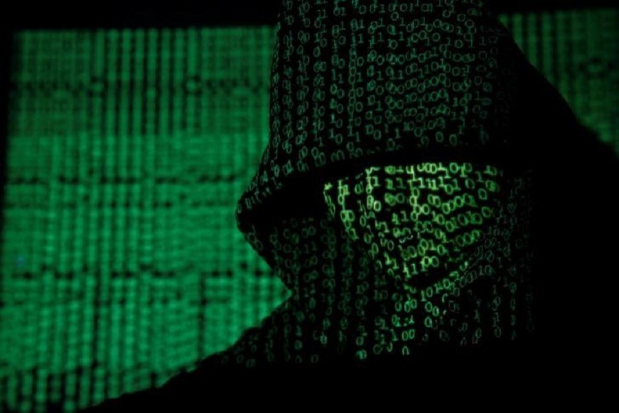 A projection of cyber code on a hooded man is pictured in this illustration picture taken on May 13, 2017. Reuters