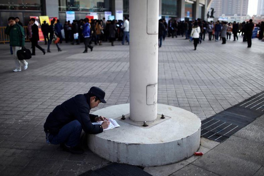 A job seeker fills in application forms during a job fair at Shanghai Stadium February 4, 2012.  - Reuters file photo