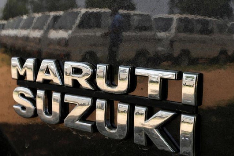 A worker is reflected on the body of a Maruti Suzuki car as he locks the door of another car at a Maruti Suzuki stockyard on the outskirts of Ahmedabad May 2, 2014. Reuters/Files